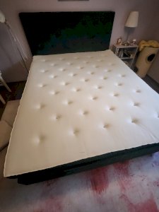 Vihreä samettikankainen sänky sekä sängyn pääty.